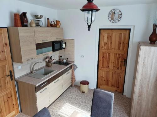 a kitchen with a sink and a microwave and a door at Chalupa Pod Menhiry in Volary