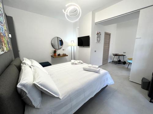 a white bedroom with a large bed and a couch at Sikelia Superior Rooms Milazzo in Milazzo