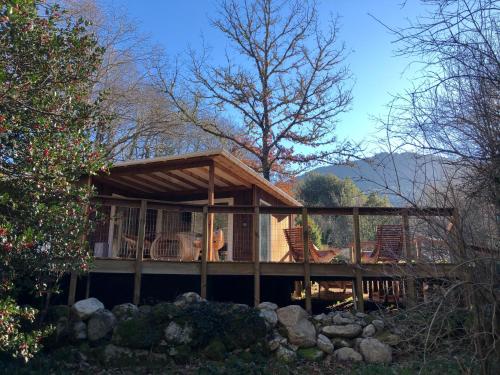 a house with a deck with chairs on it at Camping le Soleil in Vivario