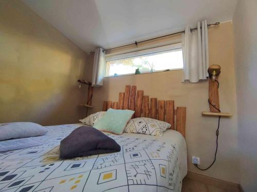 a bedroom with a bed with pillows and a window at Arche de Noé atypique, bohème , nature, piscine chauffée de Pâques à Toussaint , spa , sauna , loisirs in Le Beausset