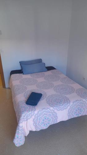 1 dormitorio con cama con almohada azul y libro en TOMMY ROOMS, en Alicante