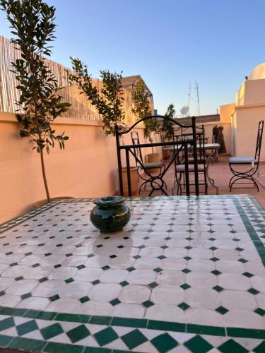 a patio with a table with a tiled floor at Riad Black Doors in Marrakesh