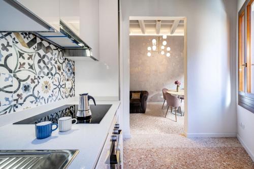 a kitchen with a sink and a dining room at Querini Suite-Balcony on canal, close to San Marco in Venice