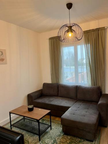 een woonkamer met een bank en een tafel bij Super appartement chaleureux à 30min de Paris in Gagny