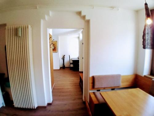 a room with a hallway with a table and a chair at Apartment Römerbrücke - Ponte Romano in Merano