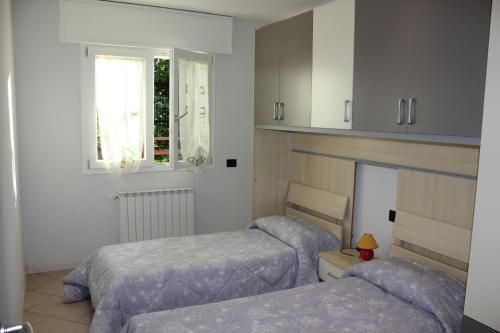 1 dormitorio con 2 camas y ventana en Casa Simone, en Omegna
