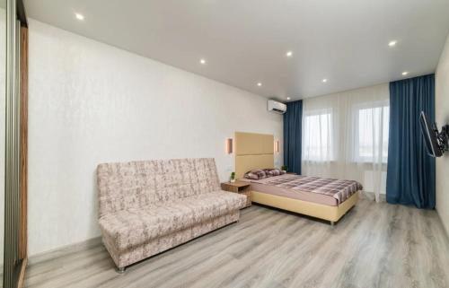 a bedroom with a bed and a couch at Two-roomed flat 68м2 in Tbilisi City