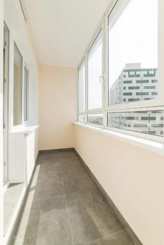 an empty room with large windows in a building at Two-roomed flat 68м2 in Tbilisi City
