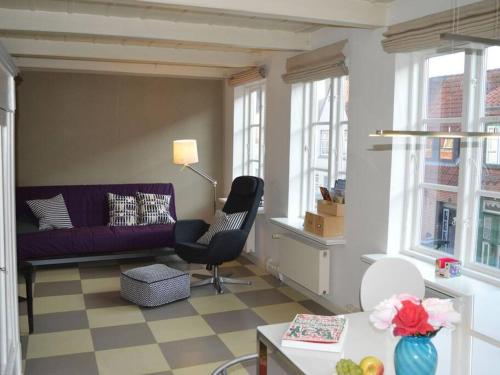 a living room with a purple couch and a chair at westcoast-Speicher in Friedrichstadt