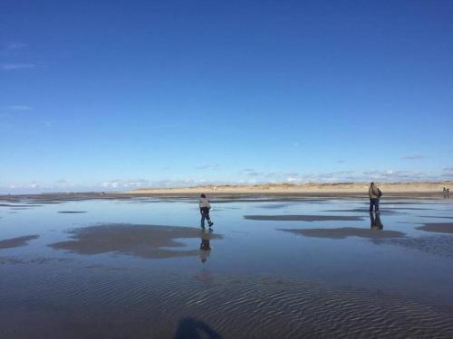 two people standing in the sand on the beach at westcoast-Speicher in Friedrichstadt