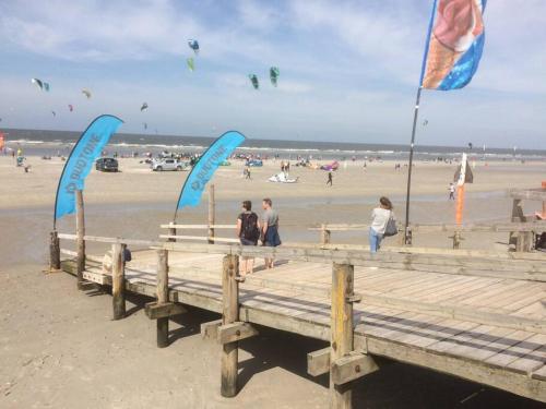 a group of people standing on a pier at the beach at westcoast-Speicher in Friedrichstadt