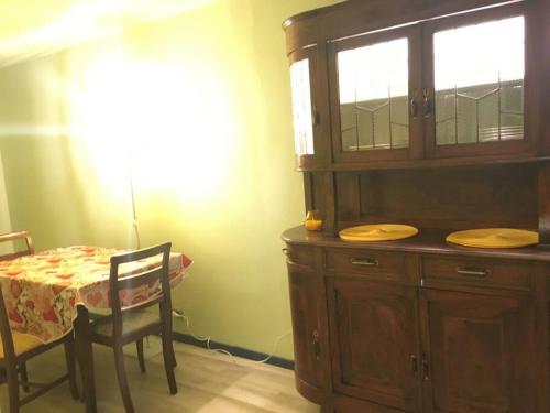 a dining room with a wooden hutch and a table with a table at KOCIA, rifugio di pace in centro in Gorizia