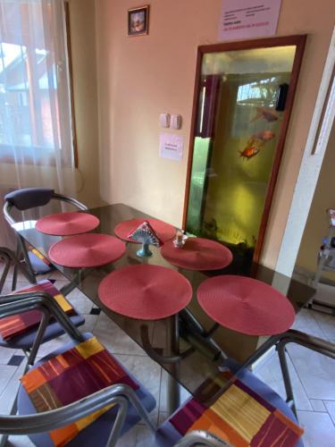a table with red seats in a room with an aquarium at Gajó Kisduna Magánház in Dunavarsány
