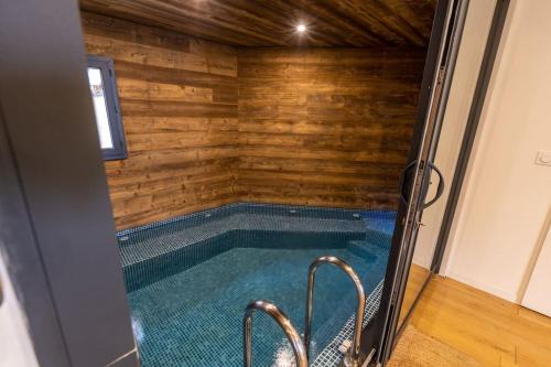 - une piscine dans une maison dotée d'un mur en bois dans l'établissement Chalet Luxe spacieux, Piscine chauffée, vue lac et montagnes, proximité immédiate pistes, aux Angles