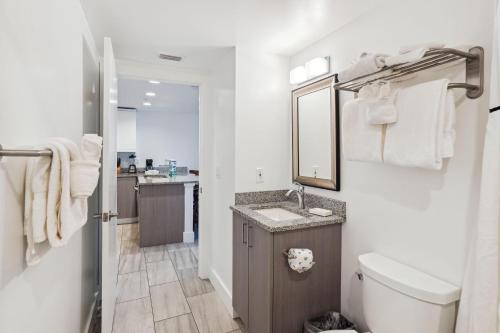 uma casa de banho branca com um lavatório e um WC em Oceana 301 East em St. Pete Beach