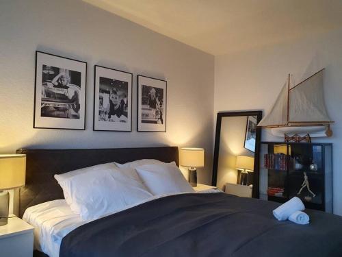 - une chambre dotée d'un lit avec 4 photos sur le mur dans l'établissement Penthouse mit einzigartigem Blick über Essen, à Essen