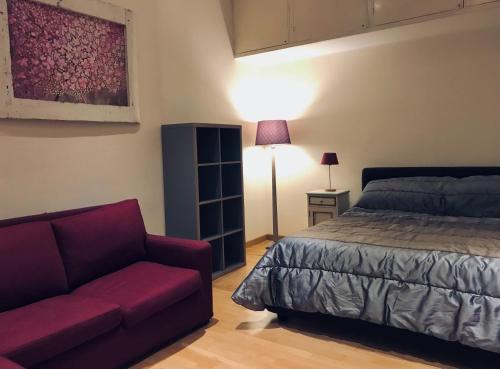 1 dormitorio con 1 cama y 1 sofá en Roma Da Noi Suite, en Roma