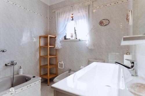 托里什韋德拉什的住宿－Casa do Pátio - 3 Bedrooms, Ponte Rol，浴室配有盥洗盆、浴缸和盥洗盆