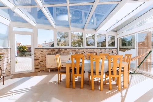 a conservatory dining room with a table and chairs at Casa do Pátio - 3 Bedrooms, Ponte Rol in Torres Vedras
