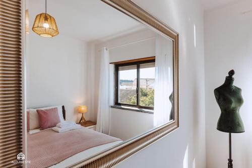 a mirror in a room with a bed and a window at Casa do Pátio - 3 Bedrooms, Ponte Rol in Torres Vedras