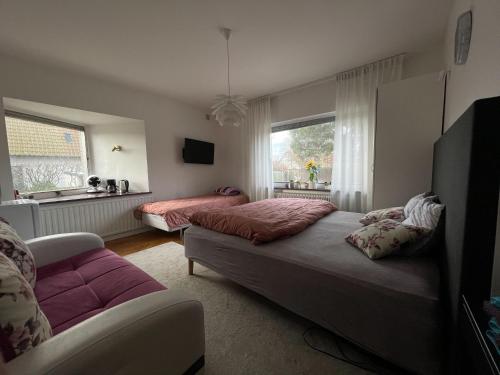 a bedroom with two beds and a couch and a window at Brabo2 in Landskrona
