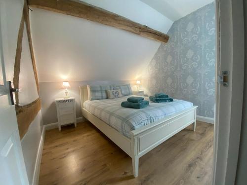 a bedroom with a bed with blue walls and wooden floors at The Buttery - RFFO in Fownhope