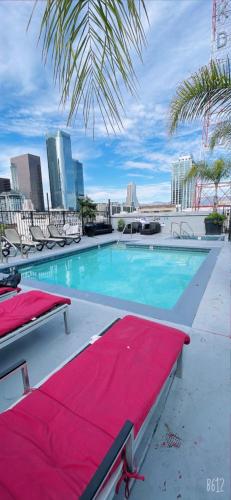 a swimming pool with chairs and a red blanket at Huge Downtown LA Loft with Rooftop Pool & Jacuzzi in Los Angeles