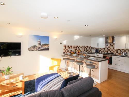 a living room with a couch and a kitchen at Park Mews in Weymouth