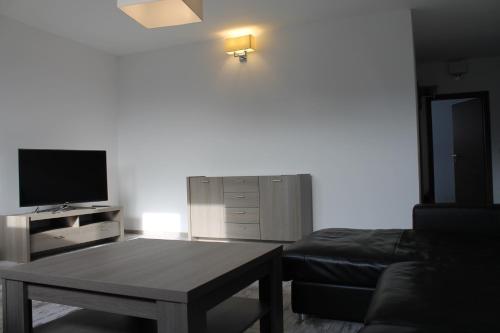 a living room with a couch and a coffee table at Penzion Bowten in Sečovce