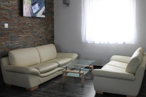 a living room with two couches and a coffee table at Penzion Bowten in Sečovce