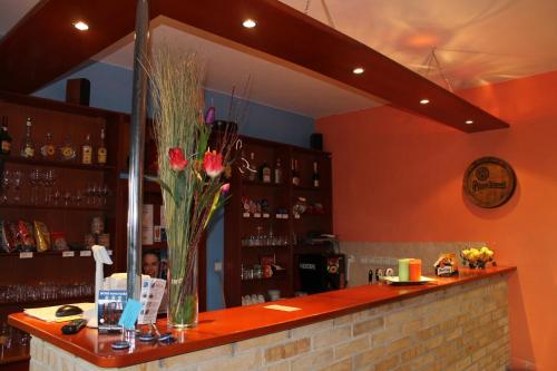 a bar with a vase of flowers on a counter at Penzion Bowten in Sečovce