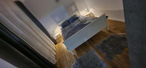 una camera con un letto bianco e pavimenti in legno di D3 ASP - VIVO Mall a Floreşti