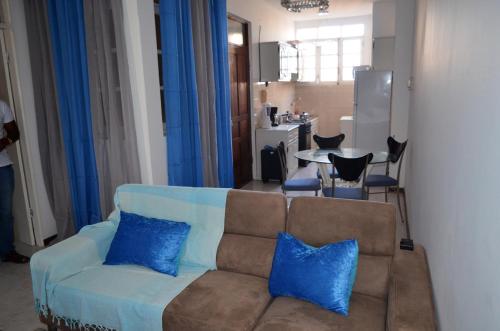 a living room with a couch with blue pillows at Plateau Apartment in Praia