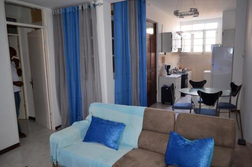 a living room with a blue couch and a kitchen at Plateau Apartment in Praia