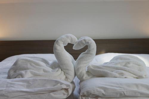 two towel swans making a heart on a bed at Penzion Bowten in Sečovce