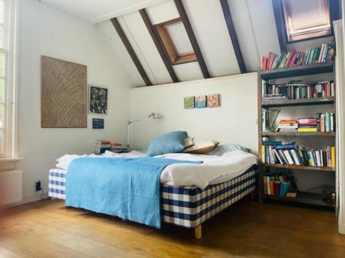 ein Schlafzimmer mit einem Bett und einem Bücherregal in der Unterkunft Heerlijke boerderij bij Veluwezoom in het Oude Dieren in Dieren