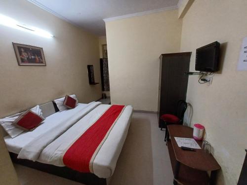 a hotel room with a large bed and a desk at Hotel Shiv Angan in Jaipur