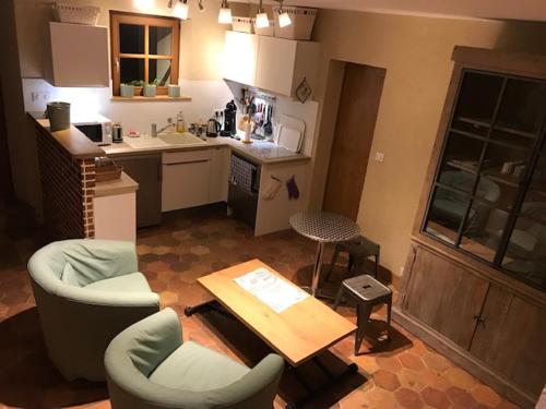 une cuisine avec deux chaises, une table et une table dans l'établissement La Ferme au colombier, à NÃ©ron