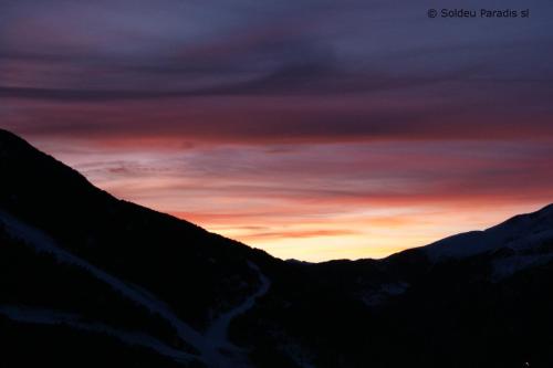 einen Sonnenuntergang über einer Bergkette mit dem Himmel in der Unterkunft Soldeu Paradis Incles in Incles