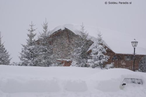 ein schneebedecktes Haus mit Bäumen im Hintergrund in der Unterkunft Soldeu Paradis Incles in Incles