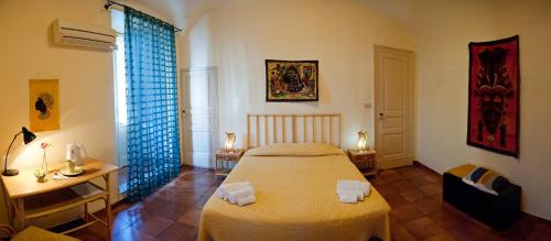 a bedroom with a bed and a desk and a window at Ivana B&B in Catania
