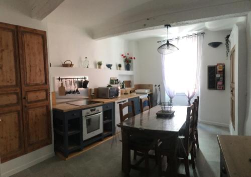 une cuisine avec une table et une cuisinière four supérieur dans l'établissement Grande Maison Village proche Verdon avec garage pour moto vélo, à Salernes