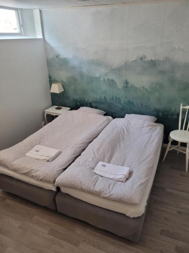 a bedroom with a bed and a painting on the wall at Bokskogens Guesthouse in Kulltorp