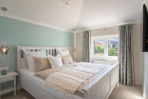 a white bed in a room with a window at Apartvilla Pag in Pag