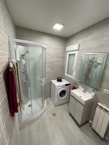 a bathroom with a shower and a washing machine at Los Robles in Ávila
