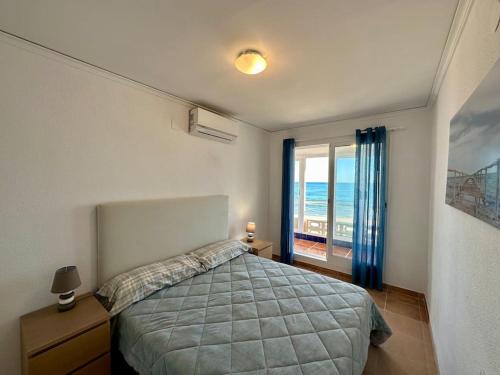 a bedroom with a bed with a view of the ocean at Breathtaking Beachfront House in Sueca