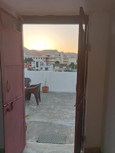 an open door to a balcony with a view of a city at Cocoon Auberge in Jaipur