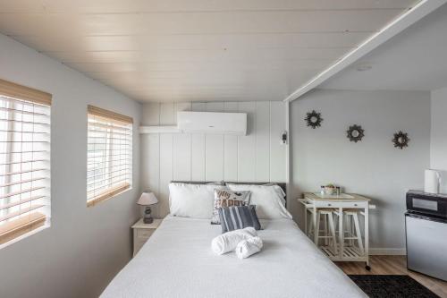 a bedroom with a white bed with towels on it at COZY Studio in Downtown San Diego in San Diego