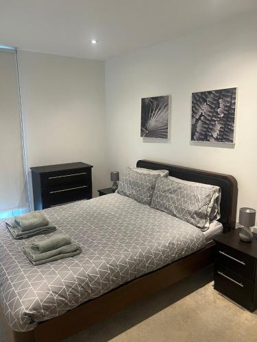 a bedroom with a bed and two pictures on the wall at Stunning 1 bedroom Apartment in Croydon in Croydon