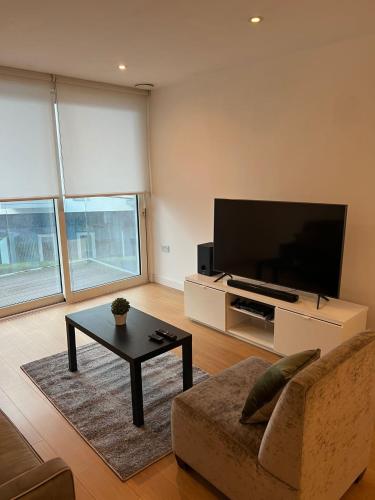 a living room with a tv and a couch and a table at Stunning 1 bedroom Apartment in Croydon in Croydon